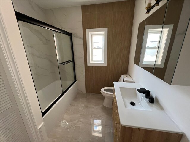 3295 Parkway Dr, Baldwin Harbor, NY 11510 - full bath featuring toilet, vanity, shower / bath combination with glass door, and marble finish flooring