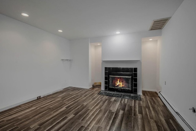 5 Charles St, Selden, NY 11784 - unfurnished living room featuring baseboard heating, wood finished floors, a tile fireplace, recessed lighting, and baseboards