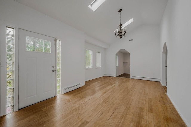 5 Charles St, Selden, NY 11784 - entrance foyer with baseboard heating, arched walkways, a chandelier, light wood-style flooring, and a baseboard radiator