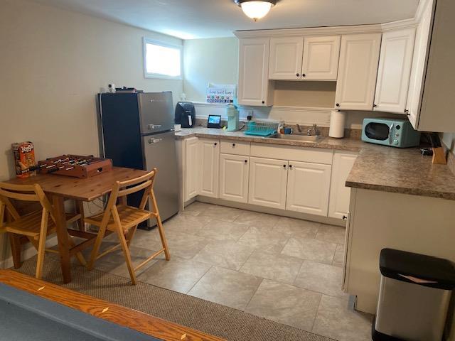 110 Sound Beach Blvd, Sound Beach, NY 11789 - kitchen with a sink, freestanding refrigerator, and white cabinets