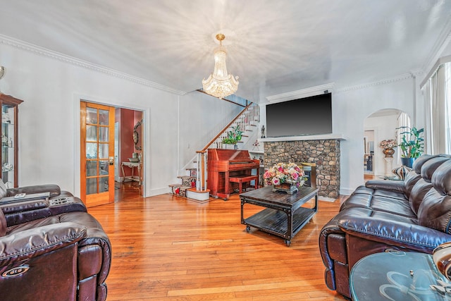 11 Whaley St, Freeport, NY 11520 - living room featuring arched walkways, stairway, light wood-style floors, a chandelier, and french doors