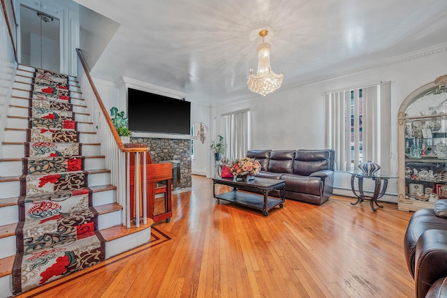 11 Whaley St, Freeport, NY 11520 - living area featuring stairs, hardwood / wood-style flooring, a chandelier, ornamental molding, and a fireplace