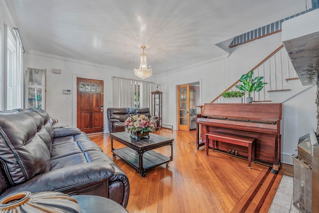 11 Whaley St, Freeport, NY 11520 - living room with a chandelier, stairs, light wood-style floors, and ornamental molding