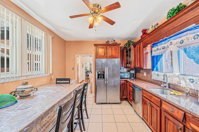 11 Whaley St, Freeport, NY 11520 - kitchen featuring appliances with stainless steel finishes, light stone counters, ceiling fan, glass insert cabinets, and light tile patterned floors