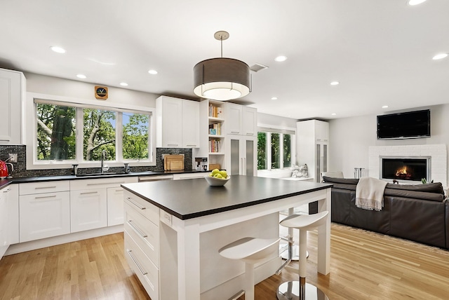 2 Lundy Ln, Larchmont, NY 10538 - kitchen with a sink, dark countertops, a glass covered fireplace, healthy amount of natural light, and recessed lighting