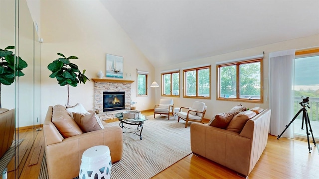 70 Jean Ct, Riverhead, NY 11901 - living room with high vaulted ceiling, light wood finished floors, a fireplace, and baseboards