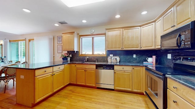70 Jean Ct, Riverhead, NY 11901 - kitchen with appliances with stainless steel finishes, a peninsula, a sink, tasteful backsplash, and light wood-style flooring