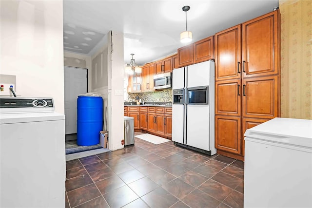 225-35 106th Ave, Queens Village, NY 11429 - kitchen featuring stainless steel appliances, washer / clothes dryer, wallpapered walls, brown cabinetry, and decorative light fixtures