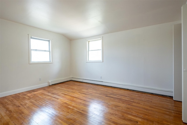 7 Arlington Rd, Ronkonkoma, NY 11779 - empty room featuring light wood finished floors, a baseboard heating unit, vaulted ceiling, and baseboards