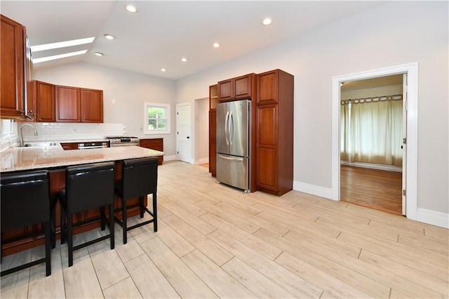 11 Brookview Blvd, Chestnut Ridge, NY 10977 - kitchen featuring stainless steel appliances, a peninsula, a sink, light wood-style flooring, and lofted ceiling