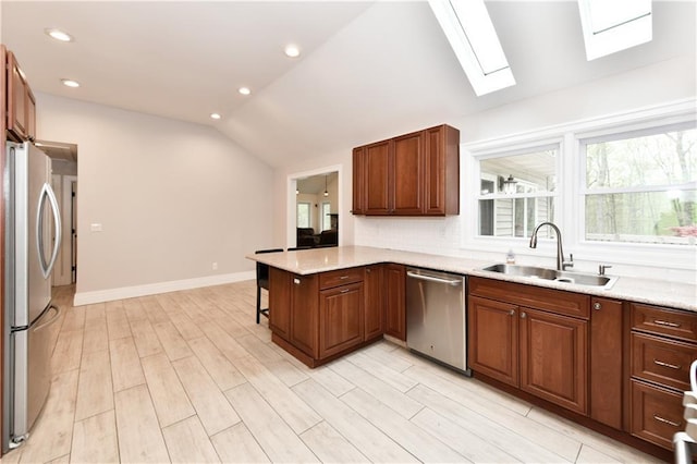 11 Brookview Blvd, Chestnut Ridge, NY 10977 - kitchen with appliances with stainless steel finishes, a sink, a skylight, vaulted ceiling, and light wood-style flooring