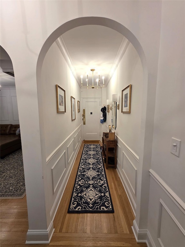 117-01 Park Ln S Unit A3C, Kew Gardens, NY 11415 - hall featuring crown molding, a decorative wall, wood finished floors, arched walkways, and wainscoting