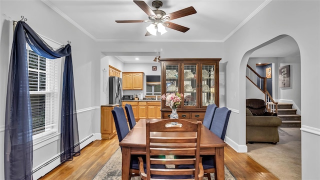 110 Driscoll Ave, Rockville Centre, NY 11570 - dining area with arched walkways, ceiling fan, light wood-style flooring, baseboards, and crown molding