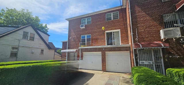 15307 79th Ave, Flushing, NY 11367 - view of front facade featuring brick siding, an attached garage, and driveway