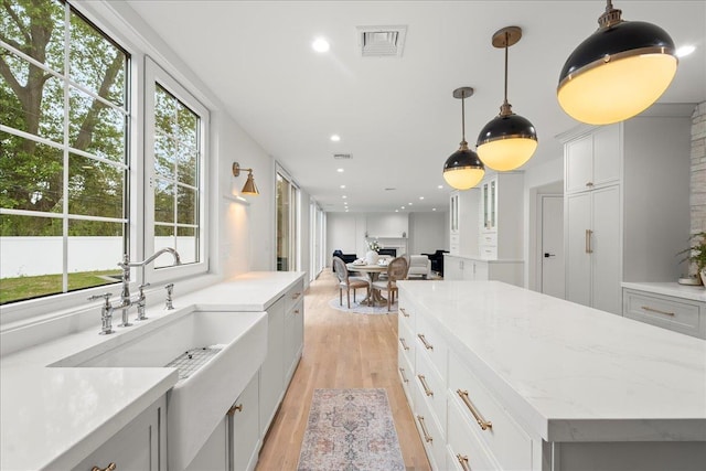 14 Kennedy Ln, West Islip, NY 11795 - kitchen with light wood-style floors, hanging light fixtures, a center island, open floor plan, and a sink