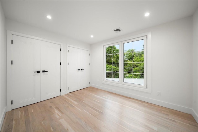 14 Kennedy Ln, West Islip, NY 11795 - unfurnished bedroom featuring multiple closets, light wood finished floors, baseboards, and recessed lighting