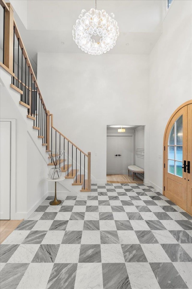 14 Kennedy Ln, West Islip, NY 11795 - entryway featuring a towering ceiling, stairway, a chandelier, and baseboards