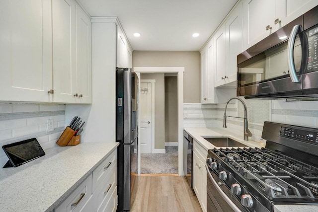 460 Old Town Rd Unit 25N, Port Jefferson Station, NY 11776 - kitchen with appliances with stainless steel finishes, a sink, light wood-type flooring, white cabinetry, and recessed lighting