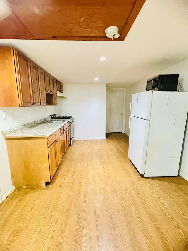 663 Woodbury Rd, Oyster Bay, NY 11791 - kitchen featuring freestanding refrigerator, black microwave, light wood-type flooring, light countertops, and baseboards