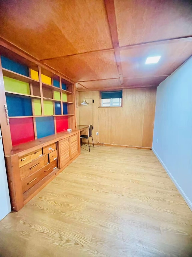 663 Woodbury Rd, Oyster Bay, NY 11791 - below grade area featuring light wood-style floors, baseboards, and wood walls
