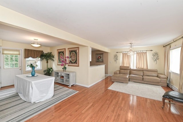 6 Country Ct, Farmingdale, NY 11735 - living area featuring light wood finished floors, healthy amount of natural light, a chandelier, and baseboards