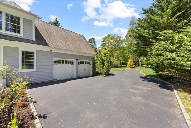 47 Valley Rd, Old Westbury, NY 11568 - view of property exterior with asphalt driveway, a garage, and a shingled roof