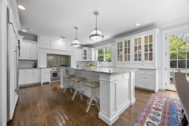 47 Valley Rd, Old Westbury, NY 11568 - kitchen featuring stainless steel range, white cabinets, backsplash, a kitchen island, and recessed lighting
