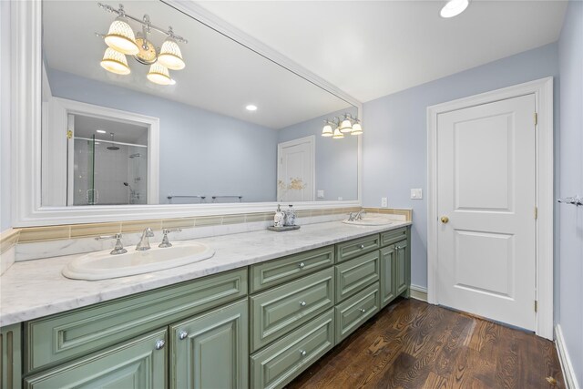 47 Valley Rd, Old Westbury, NY 11568 - bathroom featuring a shower with door, wood finished floors, double vanity, a chandelier, and recessed lighting
