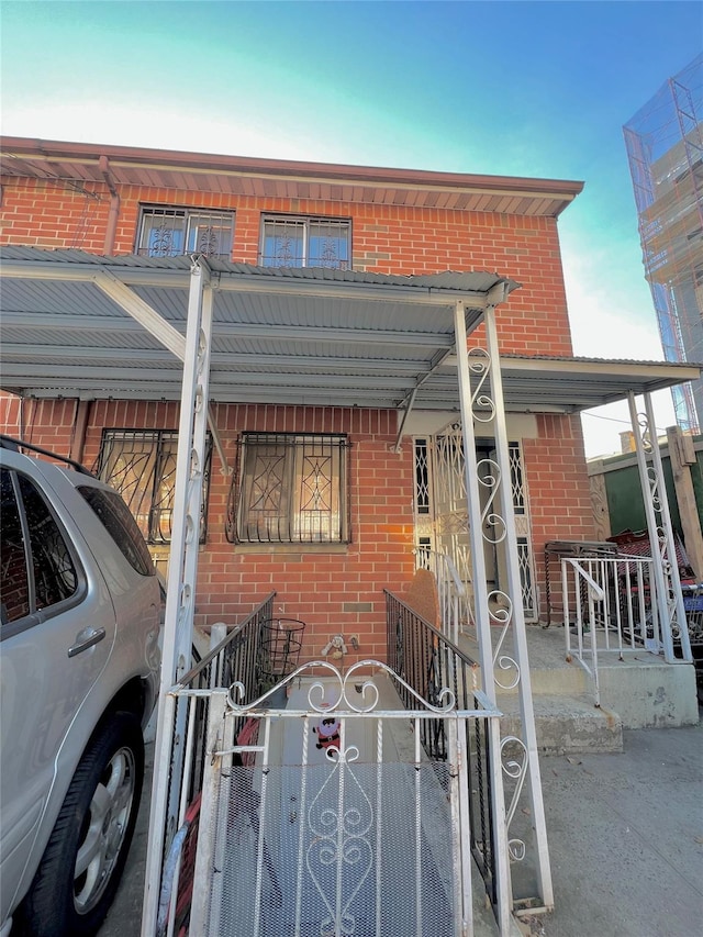 620 E 182nd St, Bronx, NY 10457 - view of front facade with brick siding, covered porch, a gate, and a fenced front yard