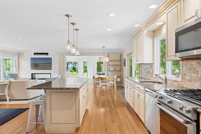 2360 Marlene Ln, Mattituck, NY 11952 - kitchen featuring stainless steel appliances, a sink, ornamental molding, open floor plan, and plenty of natural light