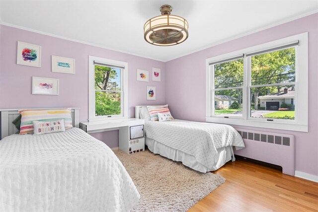 2360 Marlene Ln, Mattituck, NY 11952 - bedroom with radiator heating unit, multiple windows, ornamental molding, and light wood-style floors
