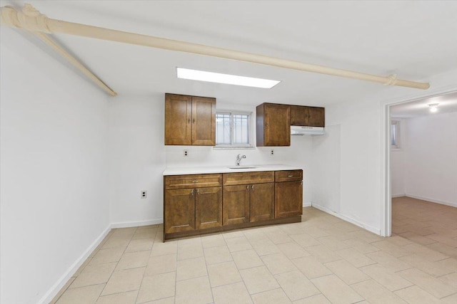 1856 Edison Ave, Bronx, NY 10461 - kitchen featuring under cabinet range hood, light countertops, a sink, and baseboards