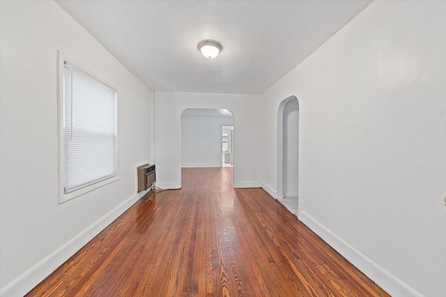 1856 Edison Ave, Bronx, NY 10461 - unfurnished room featuring arched walkways, a wall mounted AC, wood finished floors, and baseboards