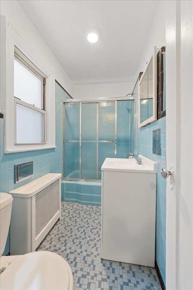 1856 Edison Ave, Bronx, NY 10461 - bathroom with tile walls, toilet, vanity, shower / bath combination with glass door, and tile patterned floors