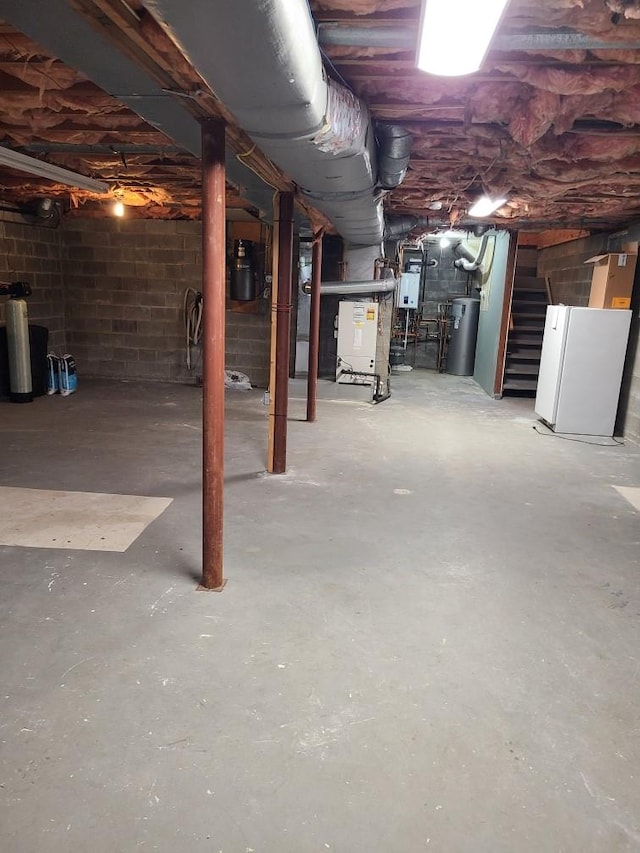 7 Mailler Ave, Cornwall, NY 12518 - unfinished basement featuring water heater, stairs, concrete block wall, freestanding refrigerator, and heating unit