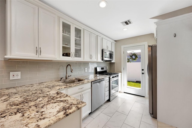 651 Hyman Ave, Bay Shore, NY 11706 - kitchen with appliances with stainless steel finishes, a sink, white cabinets, light stone countertops, and recessed lighting
