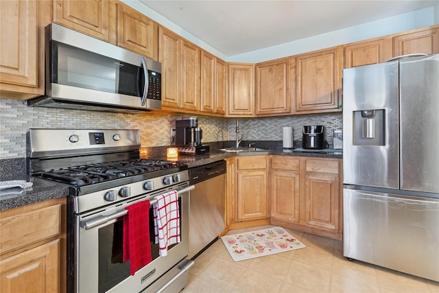 32 Blueberry Cmn, Riverhead, NY 11901 - kitchen featuring stainless steel appliances, backsplash, light tile patterned flooring, and dark stone countertops