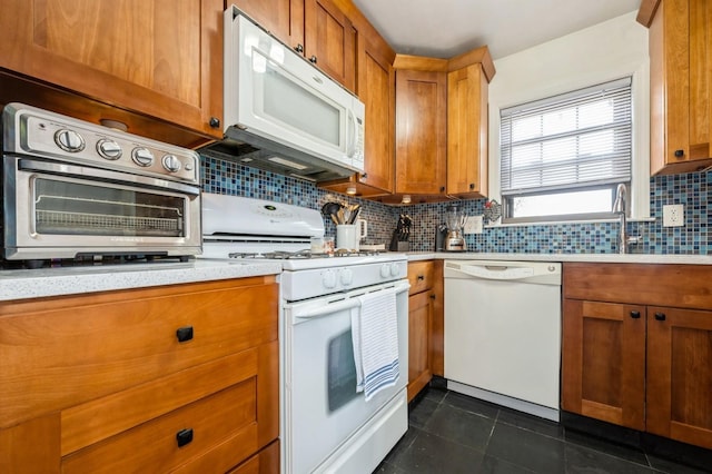 240 Mariners Way, Copiague, NY 11726 - kitchen with white appliances, light countertops, brown cabinetry, decorative backsplash, and a sink