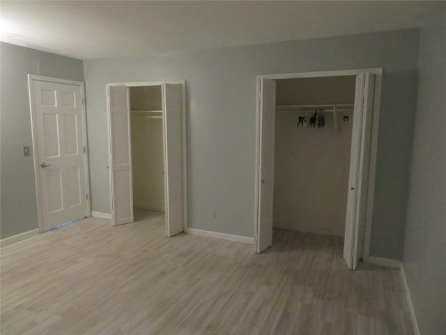 2453A Union Blvd Unit 21A, Islip, NY 11751 - unfurnished bedroom with multiple closets, light wood-type flooring, and baseboards