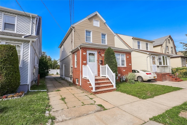 105 Pilgrim Pl, Valley Stream, NY 11580 - view of front of house featuring brick siding and a front yard