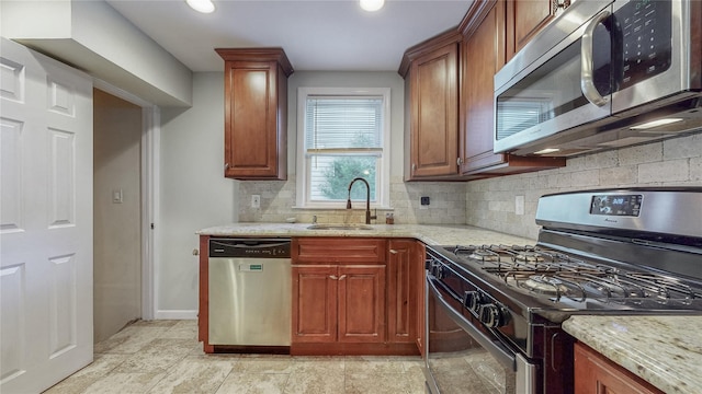 105 Pilgrim Pl, Valley Stream, NY 11580 - kitchen featuring stainless steel appliances, a sink, tasteful backsplash, light stone countertops, and baseboards