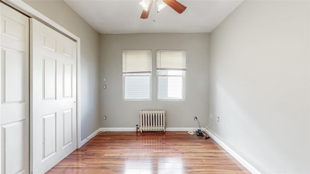 105 Pilgrim Pl, Valley Stream, NY 11580 - unfurnished bedroom featuring radiator, wood finished floors, baseboards, ceiling fan, and a closet