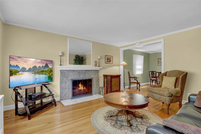 61 Maple Dr, New Hyde Park, NY 11040 - living room featuring wood finished floors, crown molding, a tile fireplace, and baseboards