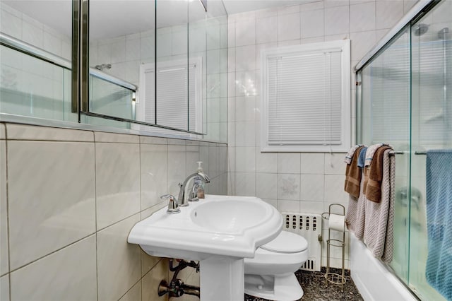 61 Maple Dr, New Hyde Park, NY 11040 - full bath with radiator, tile walls, toilet, and combined bath / shower with glass door