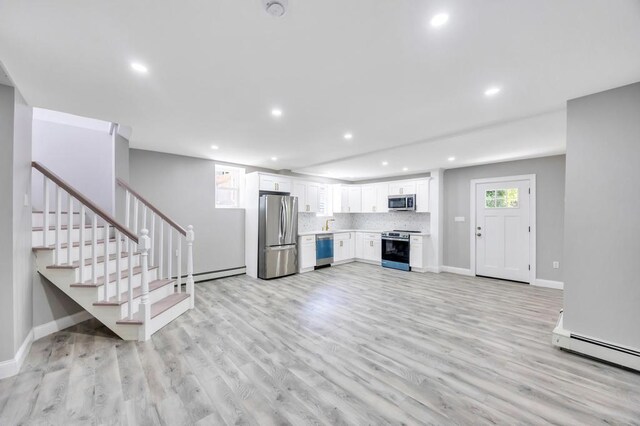 63 Ridgeway Ave, Setauket, NY 11733 - kitchen featuring appliances with stainless steel finishes, recessed lighting, light wood-style flooring, white cabinets, and baseboards