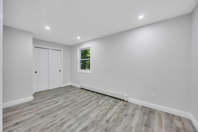 63 Ridgeway Ave, Setauket, NY 11733 - unfurnished bedroom with baseboard heating, baseboards, recessed lighting, and wood finished floors