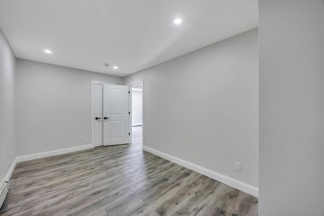 63 Ridgeway Ave, Setauket, NY 11733 - empty room with baseboards, recessed lighting, wood finished floors, and a baseboard heating unit