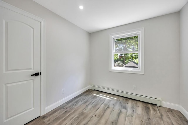 63 Ridgeway Ave, Setauket, NY 11733 - empty room with a baseboard heating unit, baseboards, light wood-type flooring, and recessed lighting