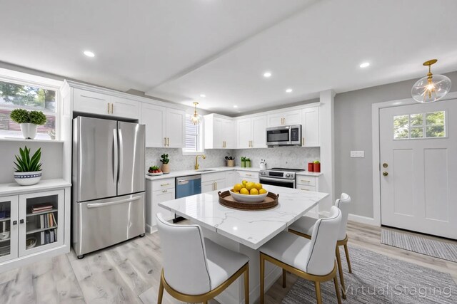 63 Ridgeway Ave, Setauket, NY 11733 - kitchen with stainless steel appliances, backsplash, light wood-style flooring, plenty of natural light, and recessed lighting