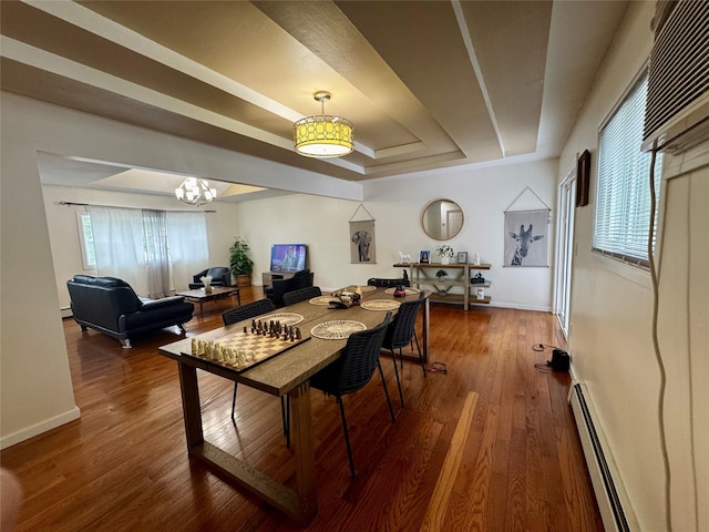 146 Grand Blvd, Brentwood, NY 11717 - dining room featuring baseboard heating, a raised ceiling, wood finished floors, a chandelier, and baseboards